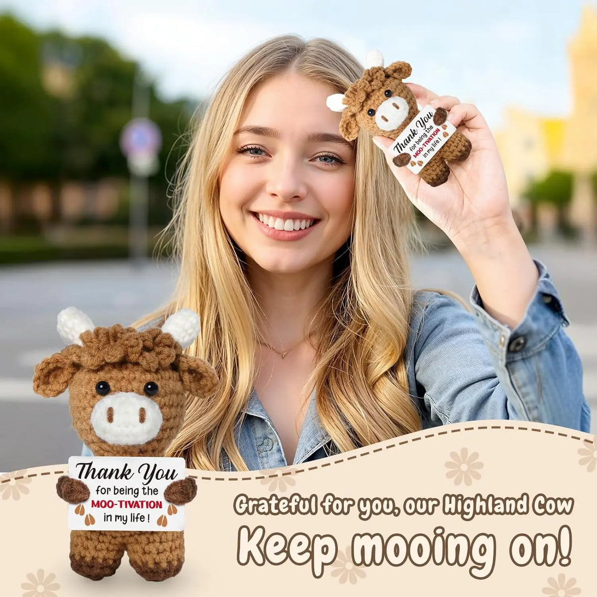 A smiling young woman holds a brown crochet cow doll with a thank you message card.