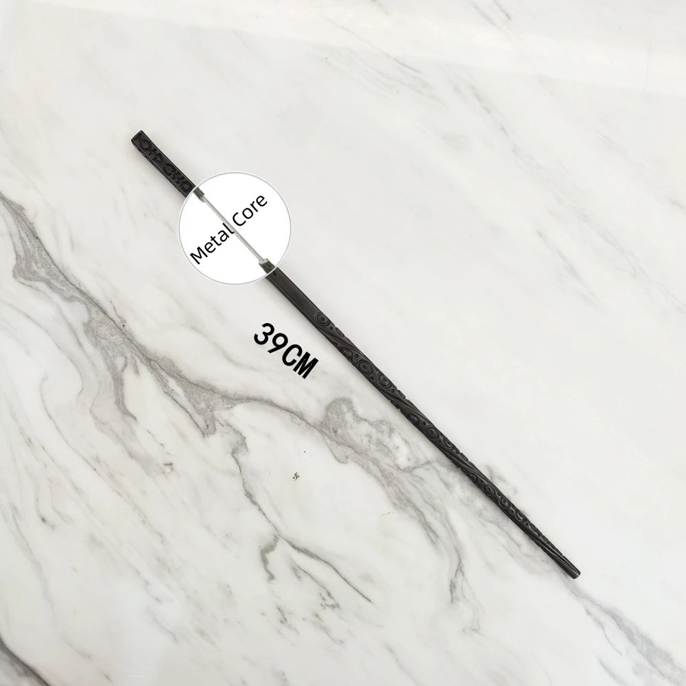 A black metal magic wand replica with a labeled metal core and a 39cm length displayed on a white marble surface.