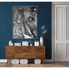 A framed canvas art piece featuring a black and white image of legs with leopard print texture hanging on a dark blue wall.