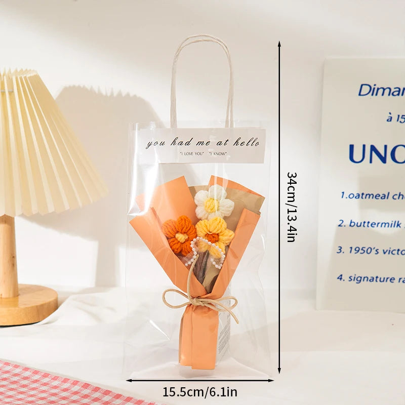 A clear plastic bag containing a handmade crochet flower bouquet wrapped in orange paper and tied with twine.