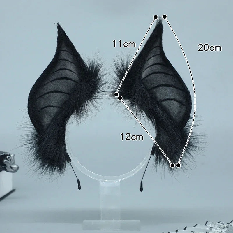 A pair of black bat simulation headwear with feathered wings displayed against a light gray background.