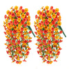 Two bunches of artificial hanging morning glory flowers in shades of orange and red with green eucalyptus leaves