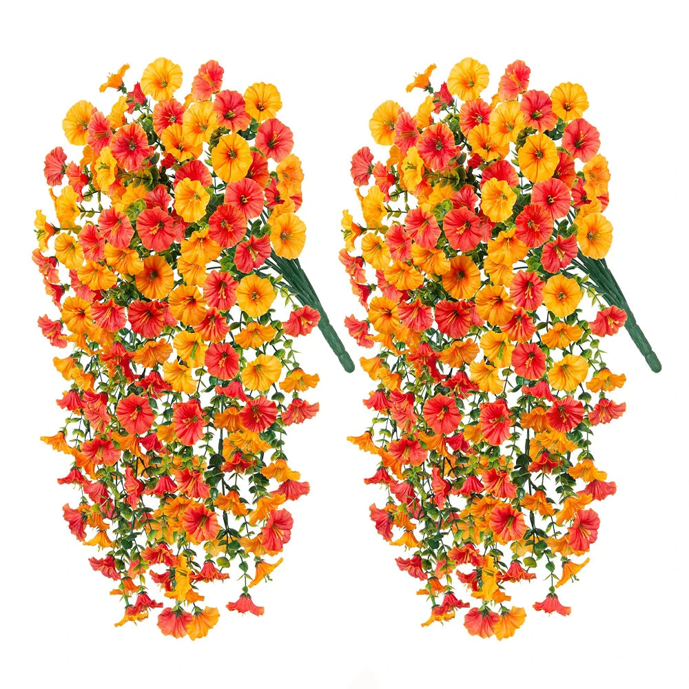 Two bunches of artificial hanging morning glory flowers in shades of orange and red with green eucalyptus leaves