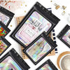 A collection of black holographic ziplock bags for jewelry and small item storage displayed on a white background.