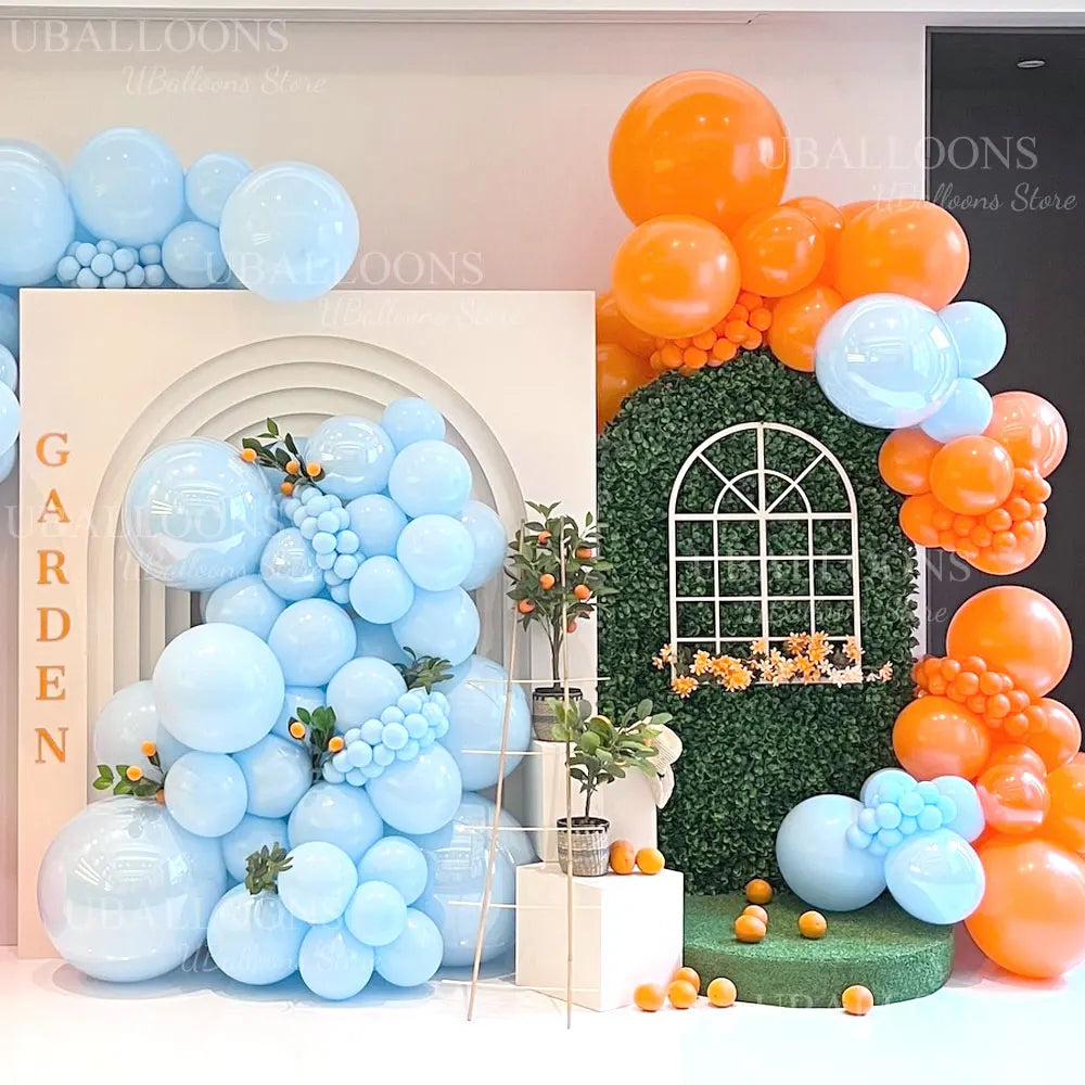 A display of pastel blue and orange balloons arranged in an archway design for parties and showers.