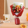 A red bouquet of handcrafted crochet sunflowers presented in a gift bag on a wooden surface.