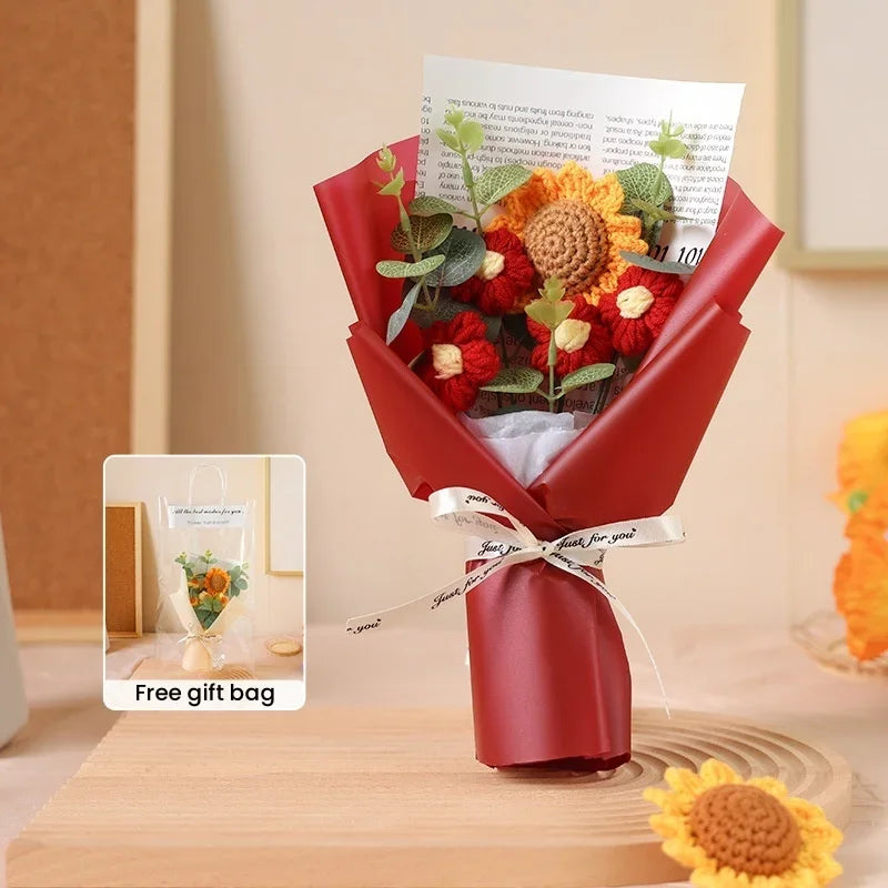 A red bouquet of handcrafted crochet sunflowers presented in a gift bag on a wooden surface.