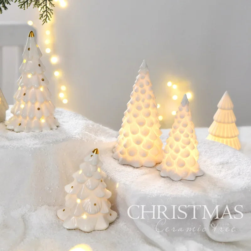 White ceramic glow-in-the-dark mini Christmas tree decor illuminated by warm lights on a snowy surface.