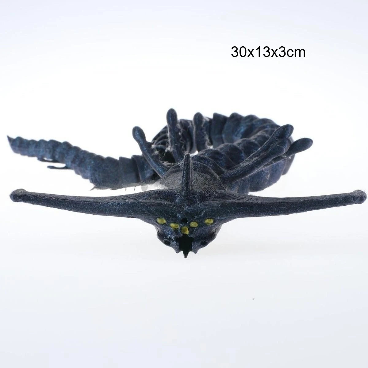 A dark blue 3D printed articulated sea monster fidget toy with textured fins and glowing eyes.