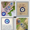 A hand holds a silver and blue Turkish Blue Evil Eye Hamsa Hand Wall Hanging Amulet.