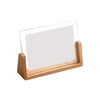 A wooden frame with a clear acrylic sheet used as a photo display for desktop use.