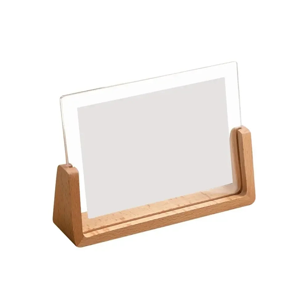 A wooden frame with a clear acrylic sheet used as a photo display for desktop use.