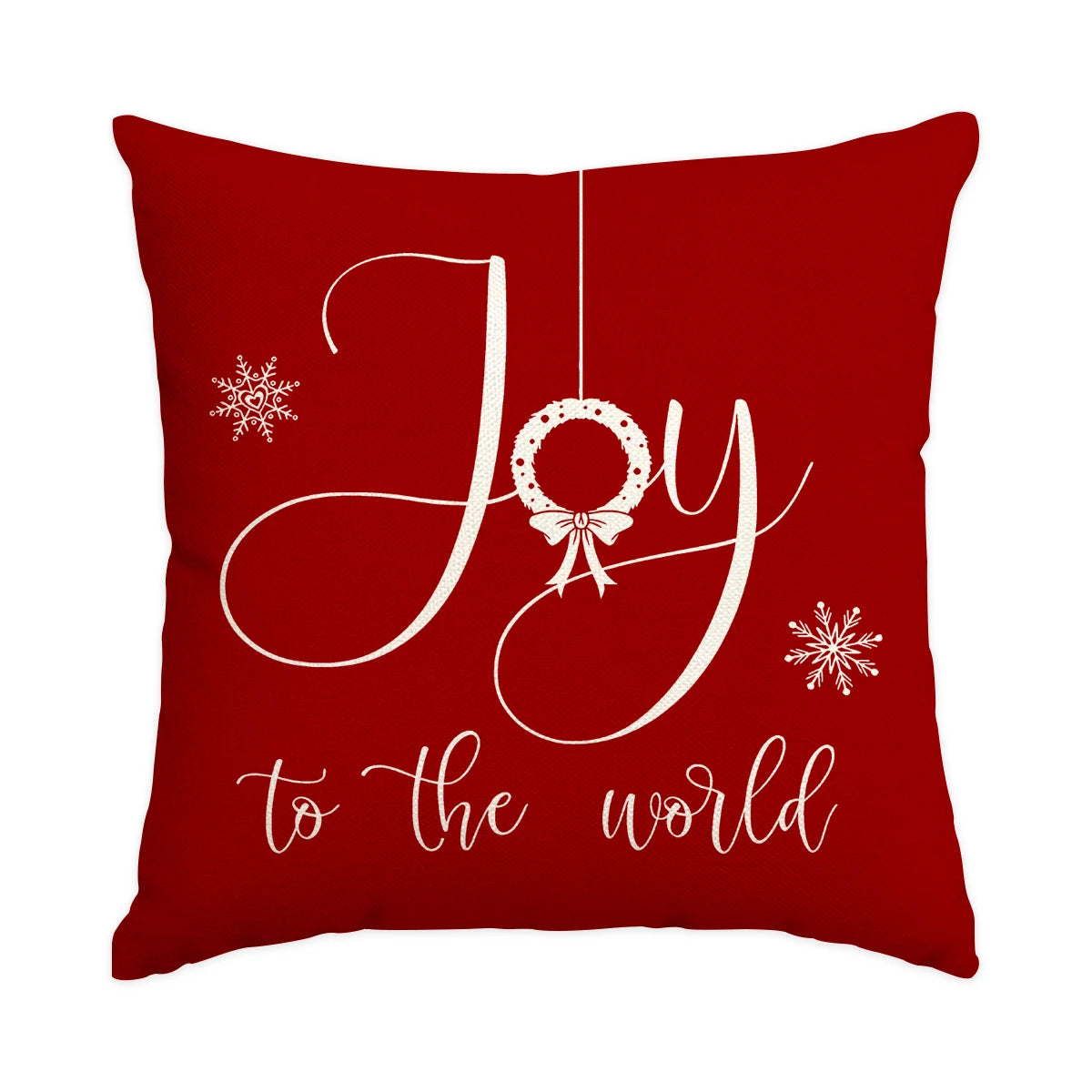 A deep red cushion cover featuring white script spelling Joy with a bow and wreath design.