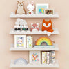 A set of two white wooden floating shelves displaying various stuffed animal toys and framed pictures.