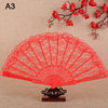 A vibrant red lace folding hand fan displayed against a beige background with red floral branches.