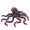 A dark red and black articulated 3D printed octopus figurine with eight tentacles.