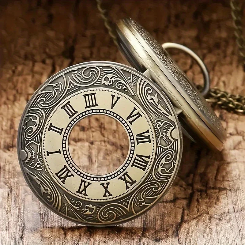 A vintage bronze quartz pocket watch with an ornate dial and chain resting on a wooden surface.