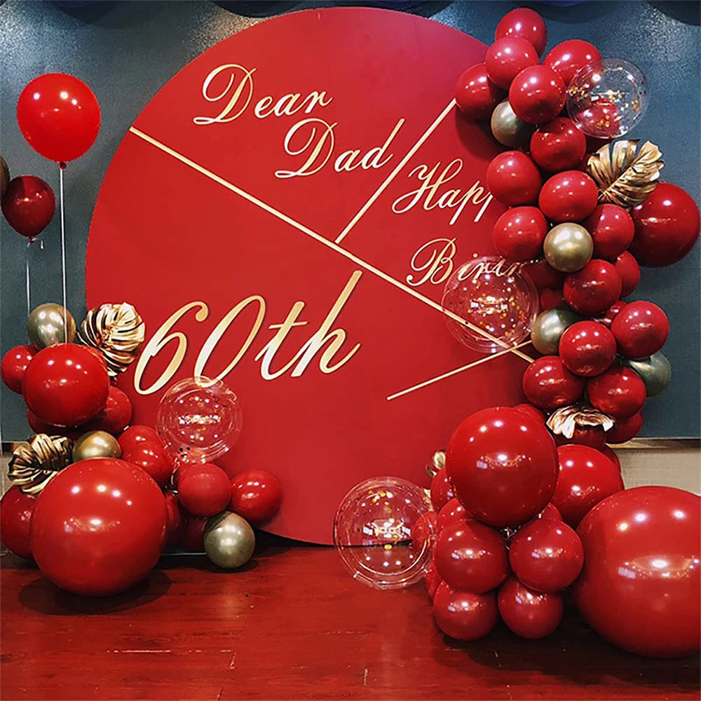 A red balloon garland arch kit featuring red and gold balloons arranged in a celebratory design.