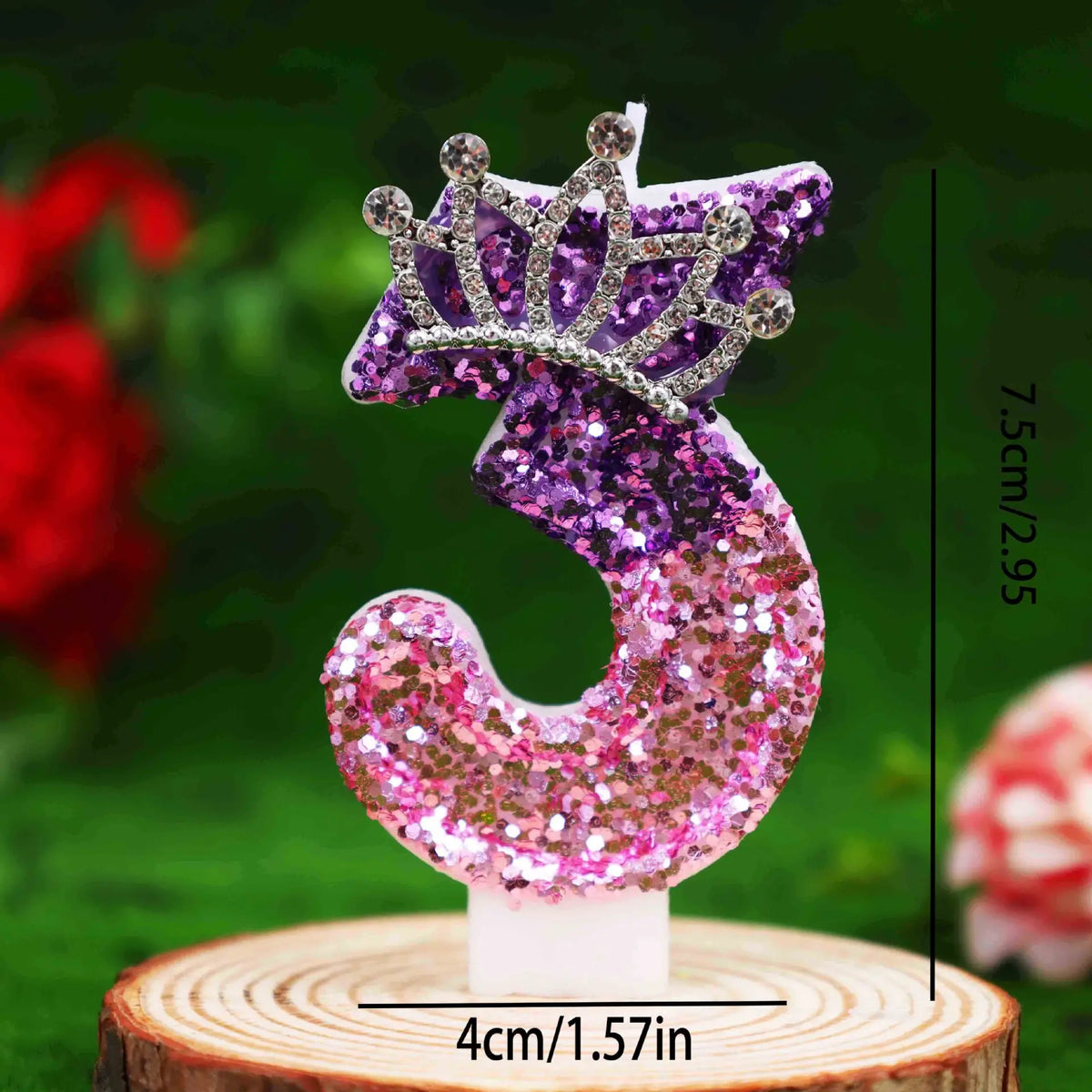 Glitter number 9 birthday candle with a rhinestone crown cake topper displayed on a wooden surface.