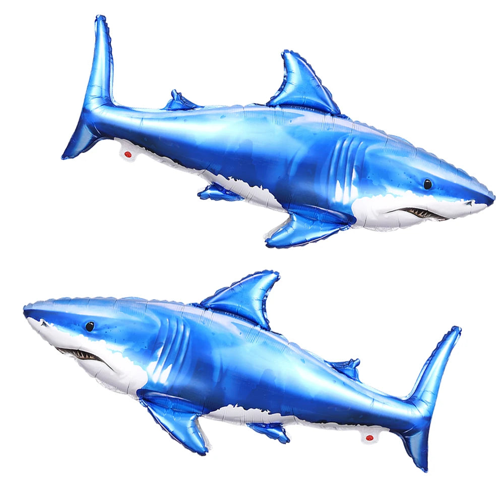 A blue foil balloon shaped like a shark swimming, used for ocean-themed party decorations.