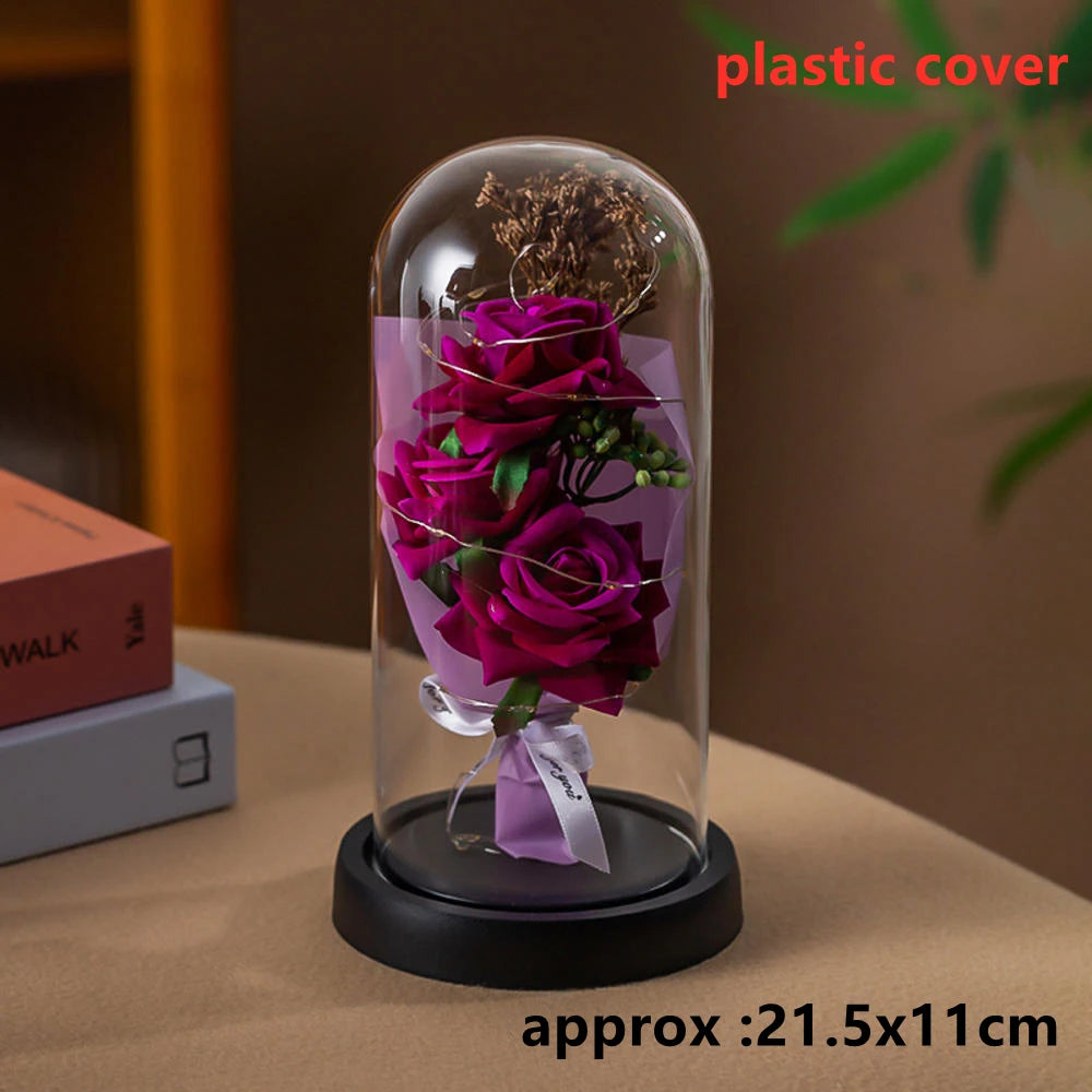 A glass dome containing a purple rose arrangement, used as an LED Galaxy Rose artificial flower.