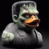 A sculpted figurine of a green-skinned duck with angry features and facial scars.