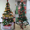 A decorated Christmas tree made of green branches and lights, displayed next to a battery-powered train toy.