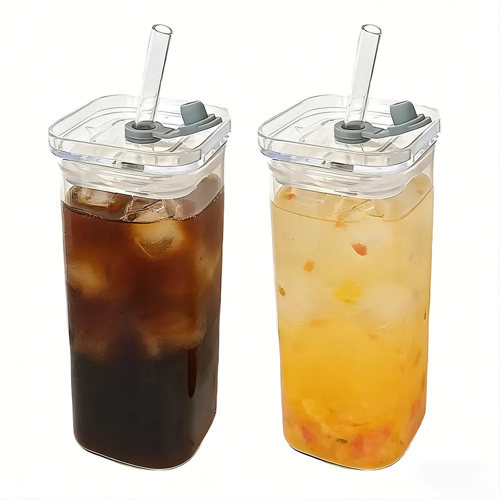 A clear glass mug filled with orange iced tea, accompanied by a lid and a clear plastic straw.