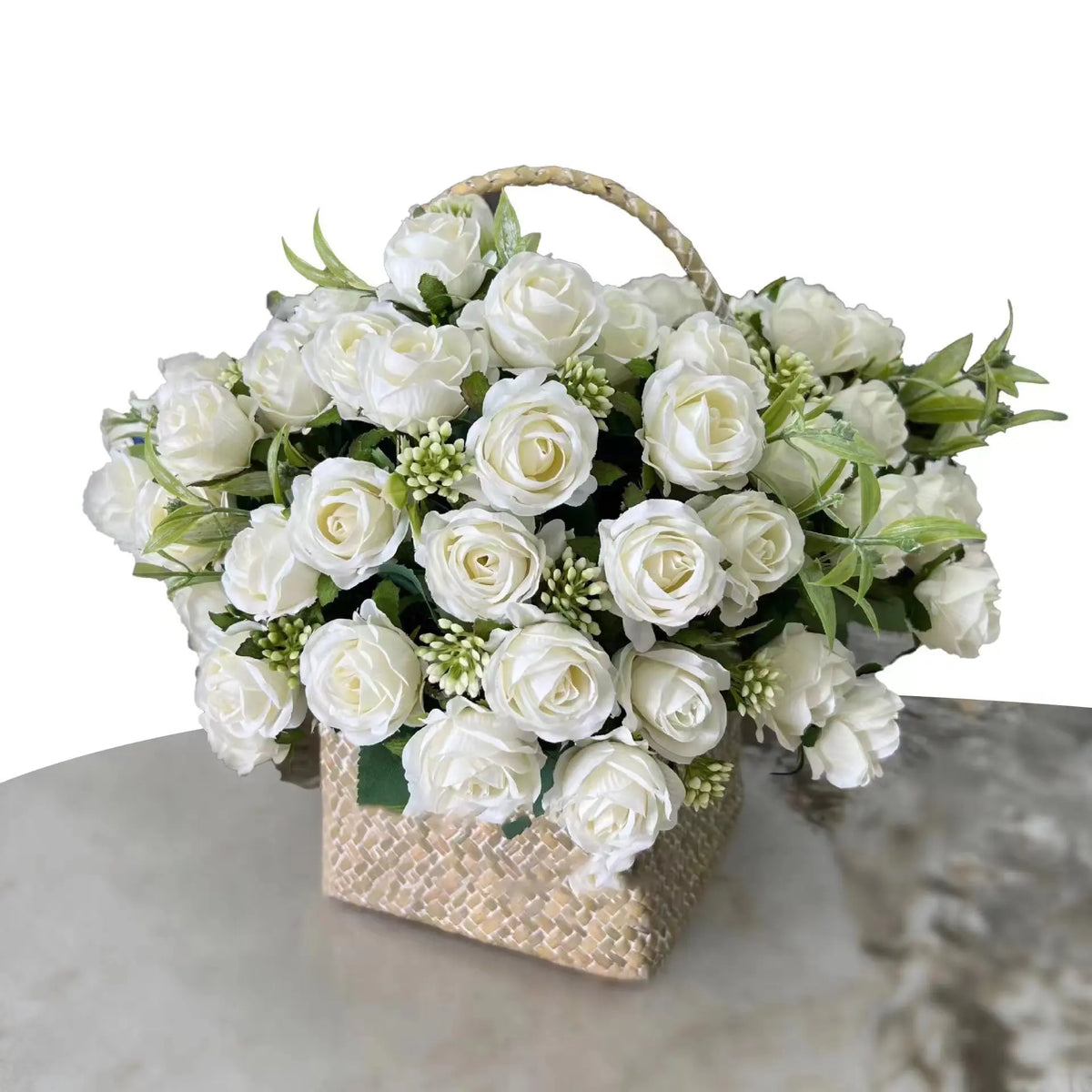 A bouquet of white artificial roses with green foliage in a woven basket.