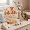 A natural wood birth announcement plaque shaped like a hot air balloon with the words Hello World and baby details