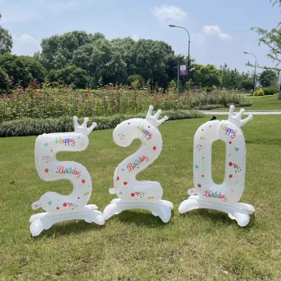 White standing foil balloon display showing the number 520 with crowns and birthday text outdoors