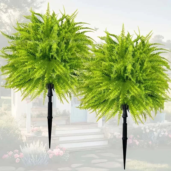 Two artificial green Persian fern stakes displayed outdoors in a garden setting.