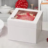 A white bakery box with a window displays red and white pastries.
