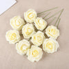 A collection of twenty creamy white foam rose stems arranged on a beige fabric background.