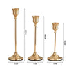 Set of three elegant gold metal candlesticks with flared bases and slender stems