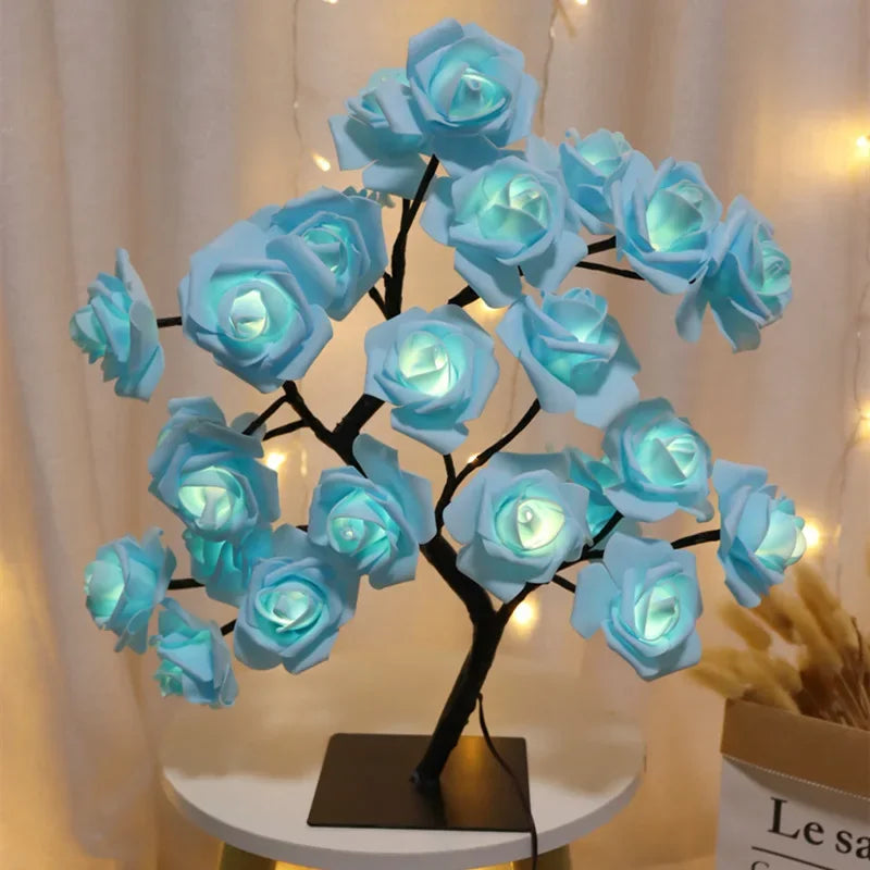 Sculpture d'arbre sombre en forme de roses bleues avec lumières LED, sur une table blanche.