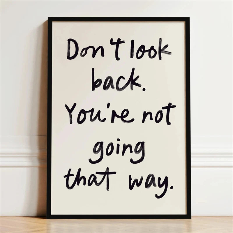 Black handwritten quote on white canvas print saying Don't look back. You're not going that way.