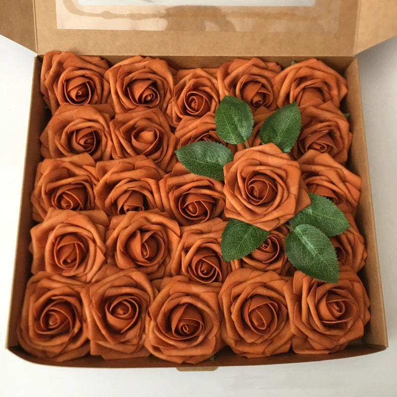 A box filled with numerous artificial real touch foam roses in shades of orange and brown.