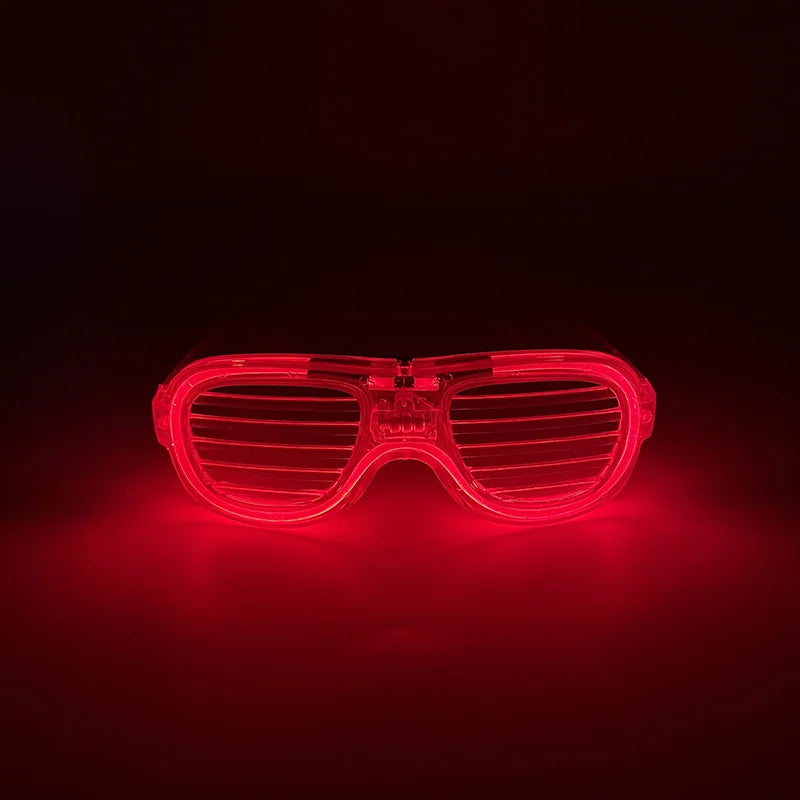 Ein Paar rote, leuchtend pinke herzförmige LED-Partybrillen, die hell gegen einen dunklen Hintergrund leuchten.