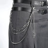 A close-up of a black belt featuring layered silver chains and a star charm.