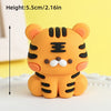 An orange tiger-shaped cake topper with black stripes and white facial features for a safari birthday party.