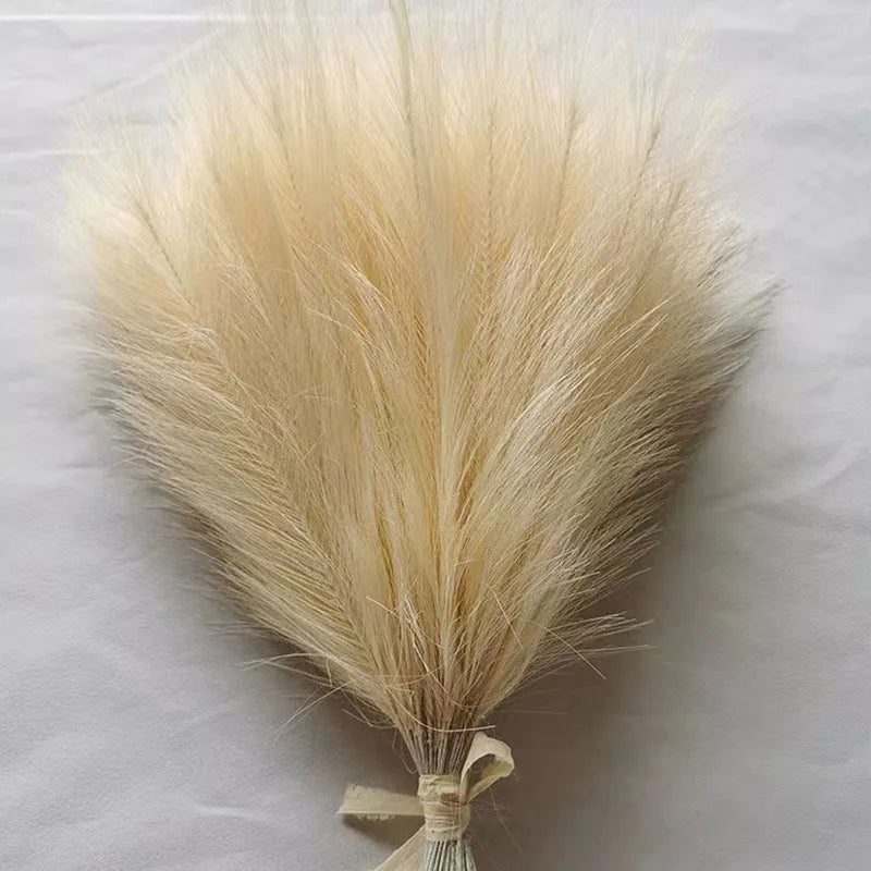 A bundle of light beige artificial pampas grass stems used for boho wedding and home decor.