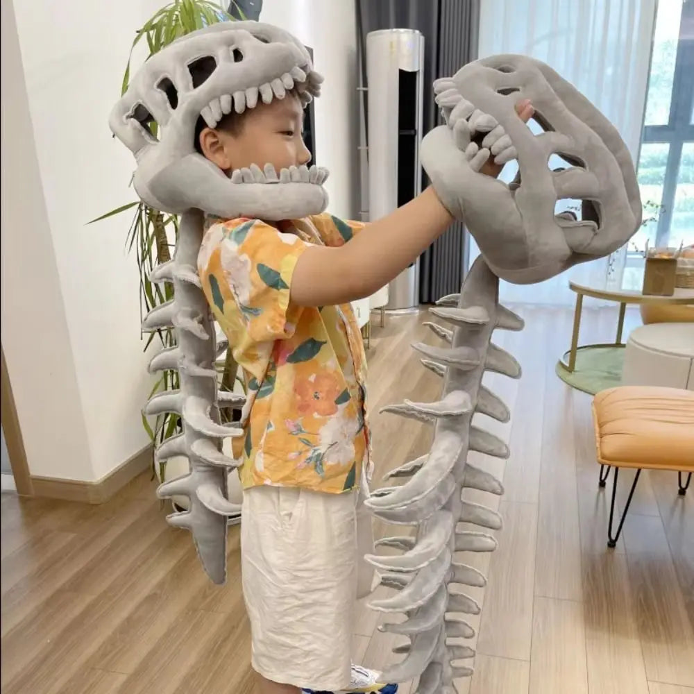A young child is wearing a gray 3D dinosaur skeleton plush costume for a Halloween or play outfit.