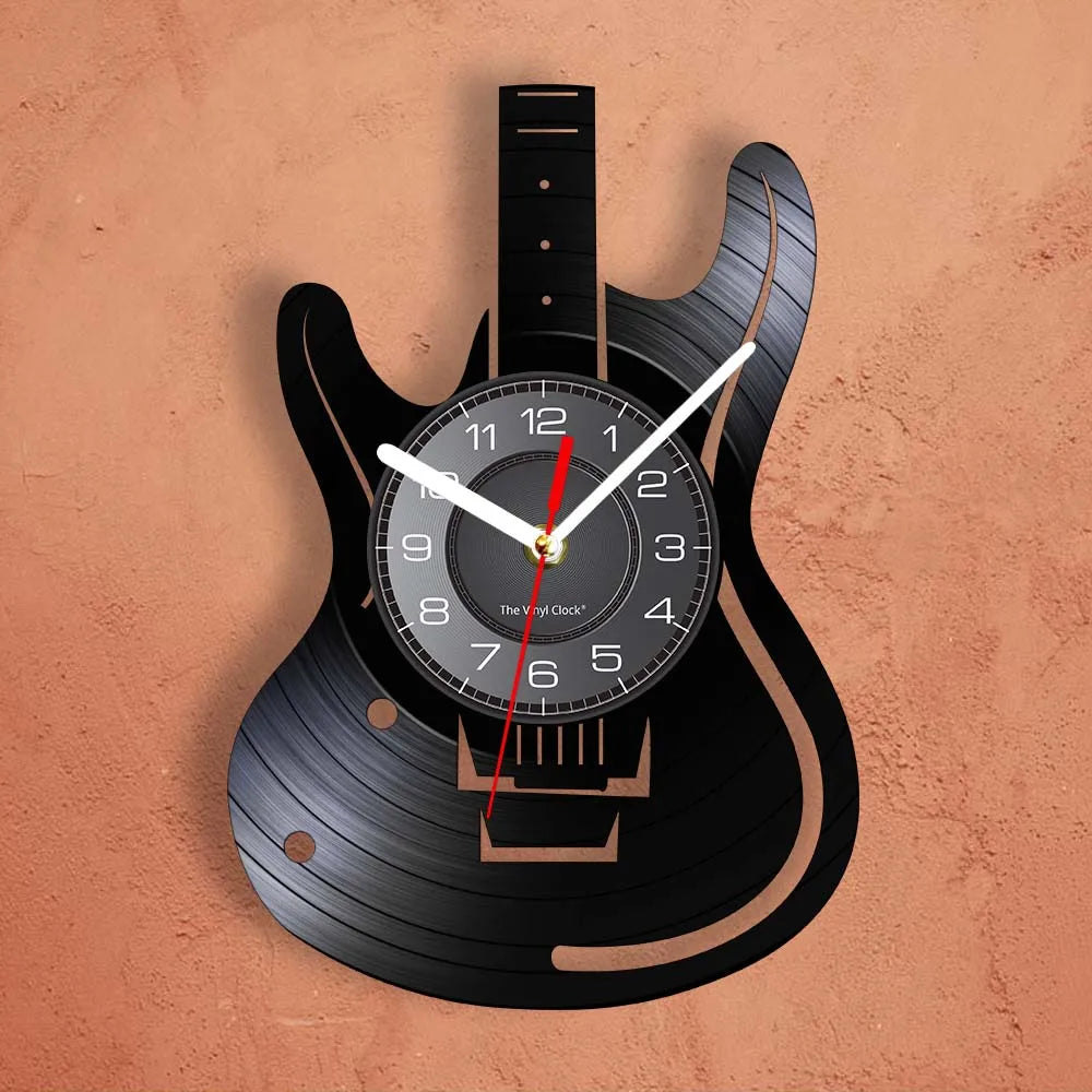 A black electric guitar body is used as a wall clock, featuring a vinyl record face with hands and a red indicator.