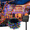 Solar powered outdoor fairy string lights illuminating a house and tree in the evening