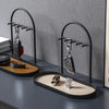 A black wrought iron desk organizer rack holding various leather and metal desk accessories.