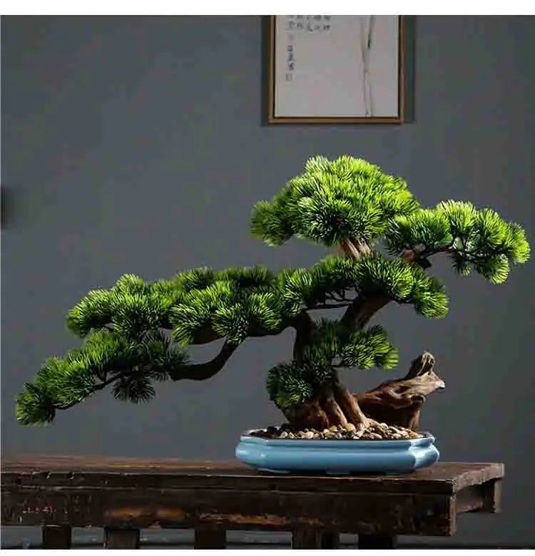 A green ceramic bonsai tree in a blue pot displayed on a wooden surface.