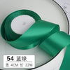 Un rouleau de ruban décoratif satin vert émeraude avec un noyau blanc et une étiquette indiquant 54 mètres.