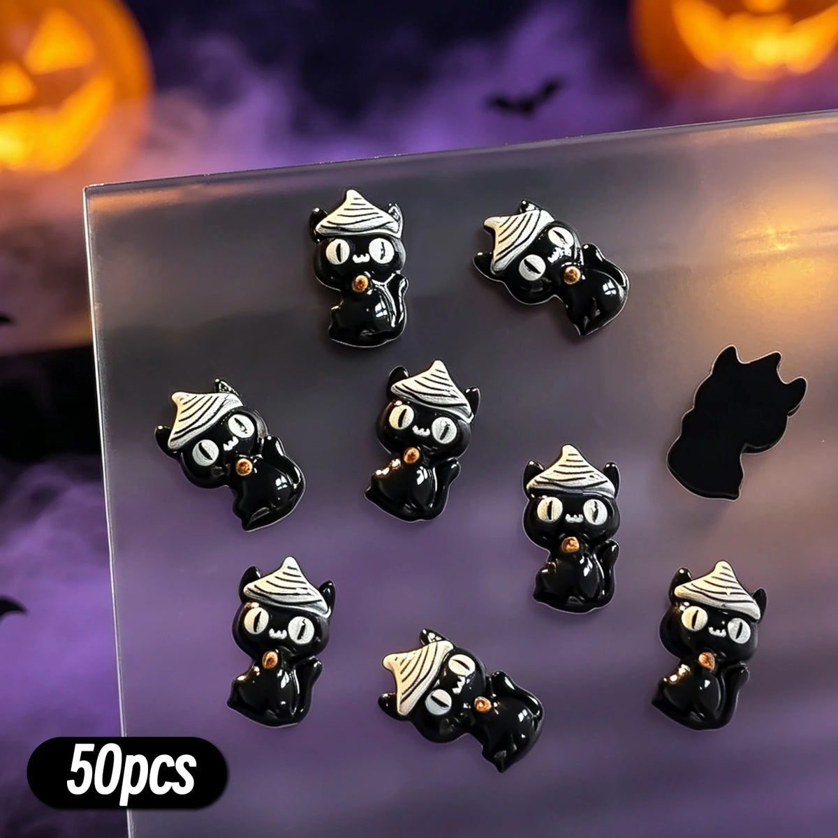 A variety pack of 50 black and white cat-themed Halloween resin nail charms displayed on a clear surface.