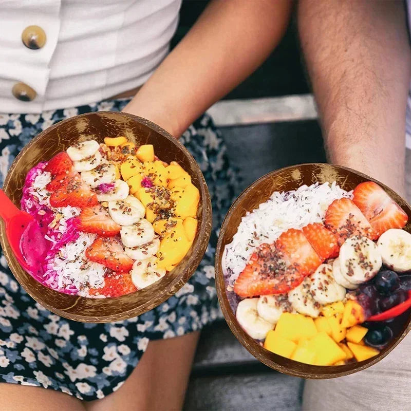 A close-up shot of three serving bowls filled with fresh fruit including strawberries, bananas, and mango slices.